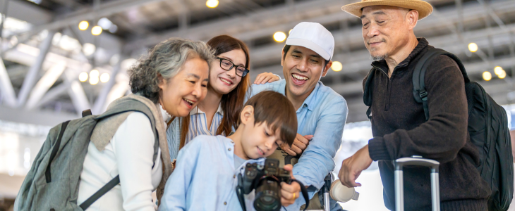 travelers smiling with suitcase.